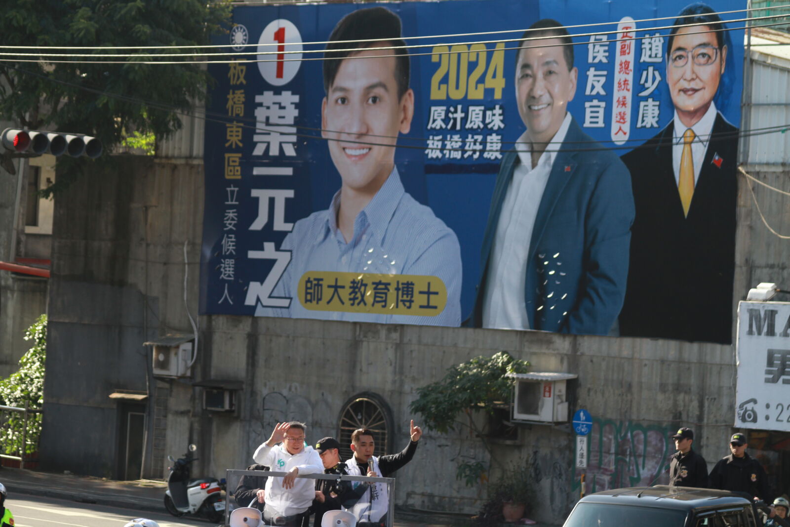 柯文哲新北車隊掃街，恰巧經過葉元之塗改看板處。（方炳超攝）